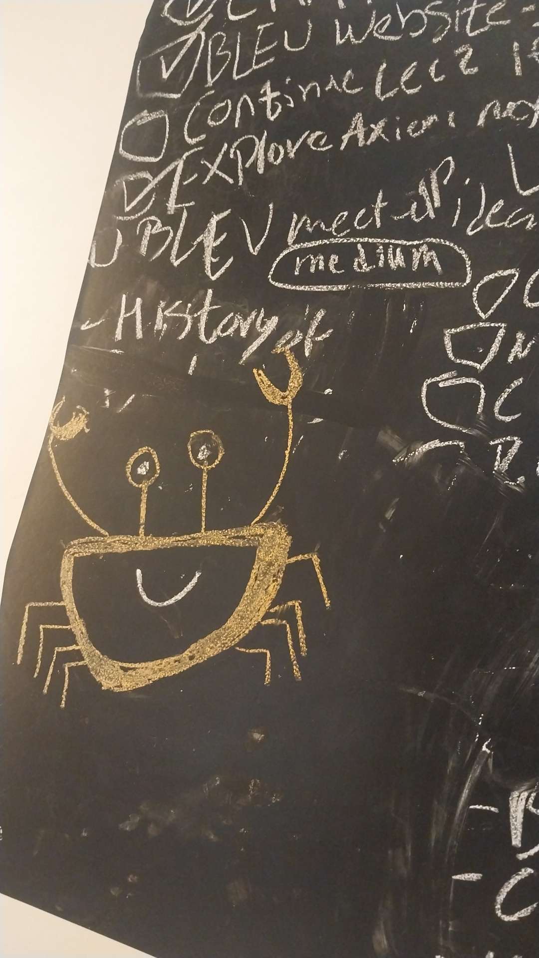The rust crab logo drawn with chalk on my black board